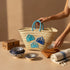 Handwoven Moroccan straw basket with embroidered shell motif