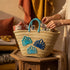 Handwoven Moroccan straw basket with embroidered shell motif