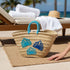 Handwoven Moroccan straw basket with embroidered shell motif