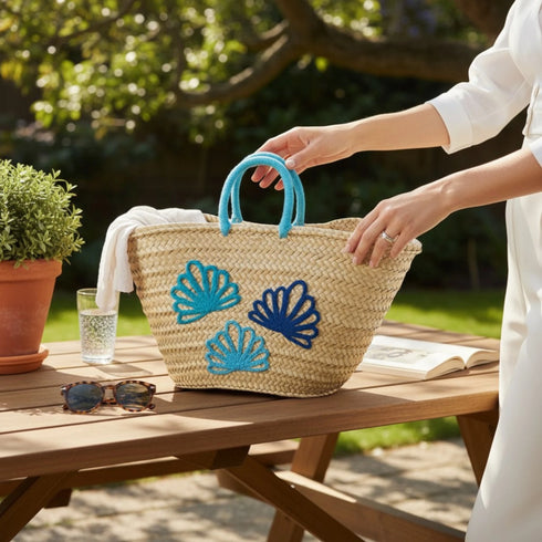 Handwoven Moroccan straw basket with embroidered shell motif