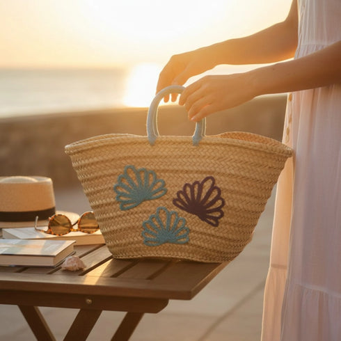 Handwoven Moroccan straw basket with embroidered shell motif